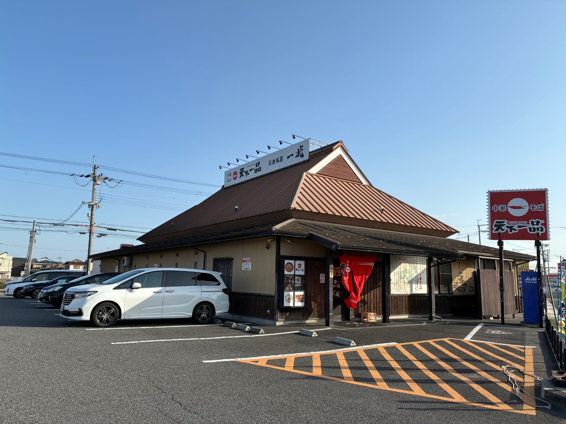 田舎茶屋 一兆 守山店の外観。茶色の大屋根と駐車場。