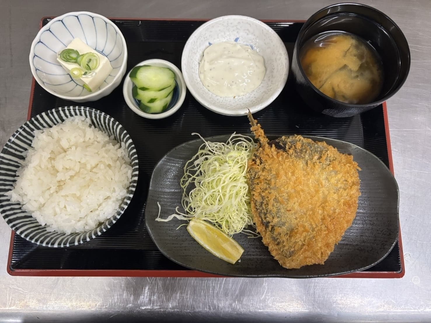 アジフライ定食。大きなアジフライとタルタルソース・ご飯・味噌汁・漬物・冷奴付き